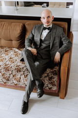 Portrait of a young groom at home before the wedding ceremony. A handsome man dressed in a classic suit. Male portrait.