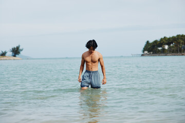 Swimming Man Embracing Vacation Vibes: Refreshing Water, Tropical Beach, and Summer Bliss
