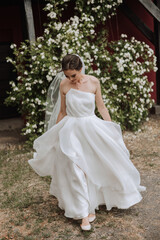 Beautiful bride with a long train. The bride in a white dress with a long train in nature on a...