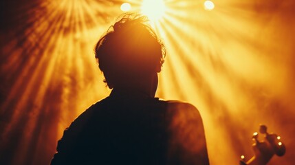 A man gazes in awe at the brilliant backlighting and lens flare, lost in the darkness of a concert, basking in the warm glow of the sun and the electrifying music - obrazy, fototapety, plakaty