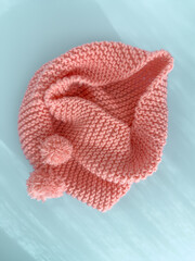 Soft pink lace knitted round scarf isolated on pastel blue background. Fashion children's accessory.