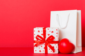 Shopping bag with gift box on colored background perspecrive view. Space for text holiday concept