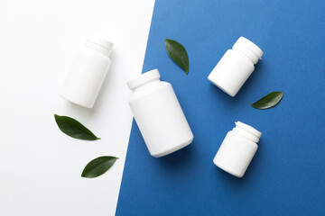 supplement pills with medicine bottle health care and medical top view. Vitamin tablets. Top view mockup bottle for pills and vitamins with green leaves, natural organic bio supplement, copy space