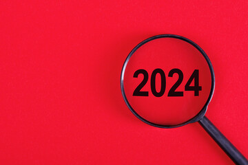 2024 inside of Magnifier glass on red background for focus current situation. 2024 present in focus business