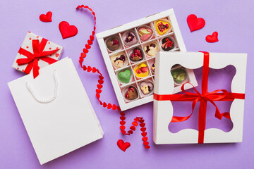 Valentine day composition: sweet candy, with gift boxes with bow and red felt hearts, photo...