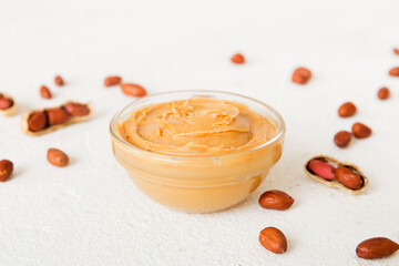 Bowl of peanut butter and peanuts on table background. top view with copy space. Creamy peanut pasta in small bowl
