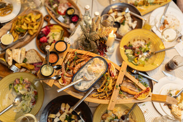 Thai food on the table includes grilled shrimp, fish boilies, squid rings. Top View.