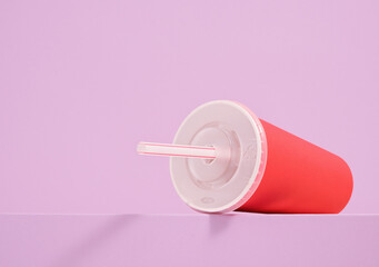 A red cup with a straw and a drink. Copy space for text.