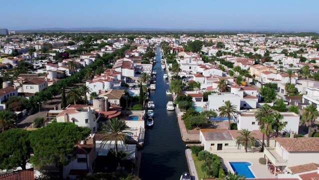 Aerial view of luxurious private community buildings in Empuriabrava. Exclusive holiday apartments or real estate for sale in Europe. Excursion on private boat. Tourist heaven destination. 
