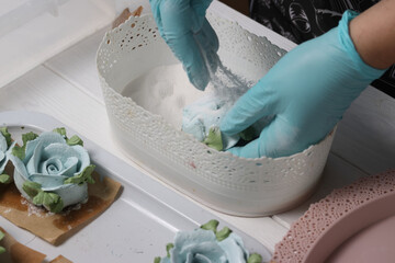 A woman sprinkles homemade zephyr with powdered sugar. Flowers from zephyr. An entrepreneur at...