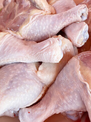 raw chicken drumsticks on the counter of the supermarket