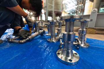 A man starts using a weld hardness the stainless steel piping flange valve component