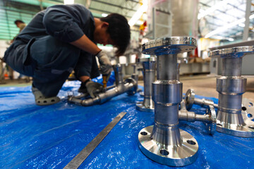 A man starts using a weld hardness the stainless steel piping flange valve component