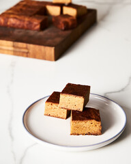 Sweet Breakfast concept. Blondies bars on white plate, light background airy mood food photo