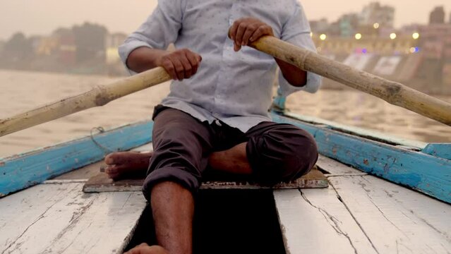 Indian Man Rowing a Boat with Oars