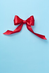 Ribbon on a blue background viewed from above. Red velvet ribbon. Top view. Copy space