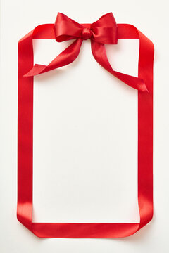 Red ribbon shaped like valentine card on light background. Top view. Copy space