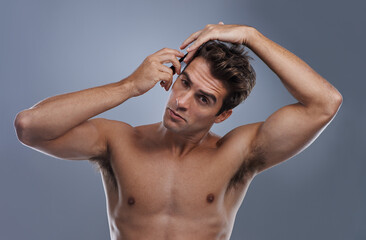 Man, portrait and comb hair in studio for grooming style on grey background for hygiene, self care...