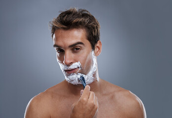 Man, razor and face with shaving in studio portrait for grooming, skin and wellness by grey...