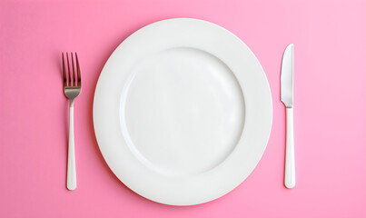 Table serving with a white empty plate, fork and knife. Pink background. Flat lay. Food serving mock up. Valentines day concept