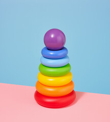 Composition with pyramid, colored rings and round purple ball. Play time.
