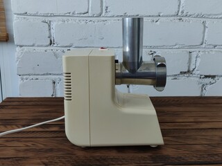Electric meat grinder on the wooden table