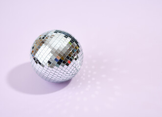 Night alcohol party. Shining mirror disco ball on a purple background. Copy space for text.