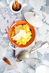 Polento corn porridge on a gray background in a brown plate.