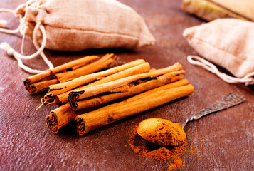 Cinnamon sticks on a wooden background. Cinnamon spice in a spoon and bowl.