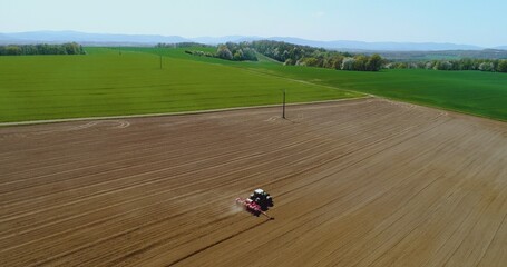 Tractor working in beautiful spacious agricultural field