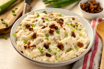 Bowl of mashed potatoes with bacon and green onion