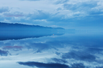 Obraz premium Evening mist by the lake in winter.