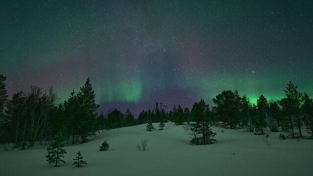 A sky full of stars and an aurora dancing beautifully over a snow covered landscape in Bod&oslash;.