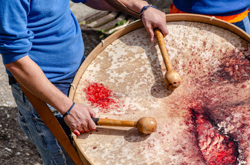 Musician hands with drum sticks playing a traditional galician bass drum during an outdoor folk...