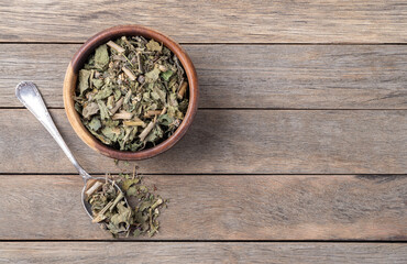 Lemon balm or Melissa dried tea leaves on a bowl over wooden table with copy space