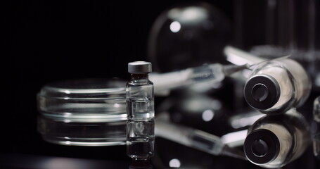 Laboratory Equipement: Syringe and Medicine, Test Tubes and Flasks Rotating on Black Background.
