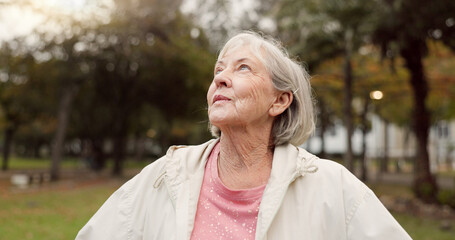 Senior woman, thinking and outdoor at the park to breathe fresh air in nature or woods on walk in retirement. Happy, face and elderly person with wellness, happiness and positive mindset or gratitude