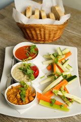 Three dip sauces with vegetables on a plate