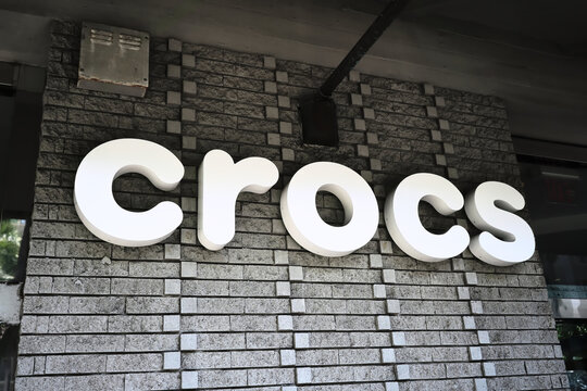 Honolulu, Hi - January 12, 2024: Crocs footwear company logo signage on store in popular Waikiki tourist destination.