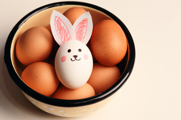 Photograph of egg with rabbit ears and several eggs in the back. Easter concept.