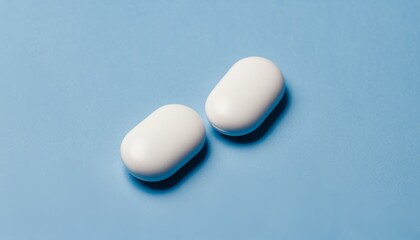 Two white pills on a blue background
