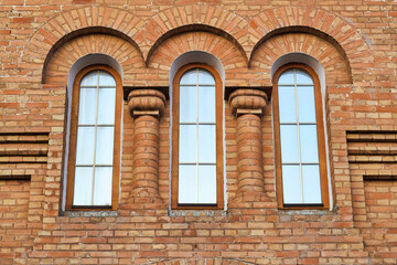 Fragment of a historical building with 3 side-by-side vertical windows