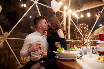 Couple clinking glasses of champagne at romantic dinner in restaurant