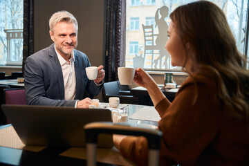 Man and woman using laptop during coffee time