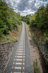 Obraz premium Dardilly, France - 08 05 2023: View of a railway track across the forest.