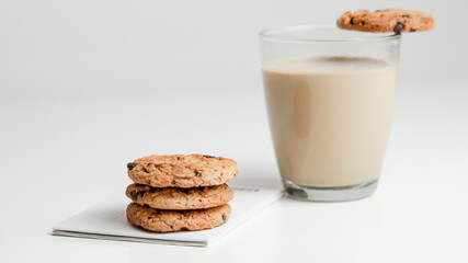Chocolate chip cookies and a glass of milk coffee on a white background