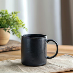 Black coffee mug sitting on a table next to a plant.