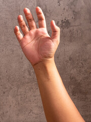 hand holding wooden tablespoon on gray background