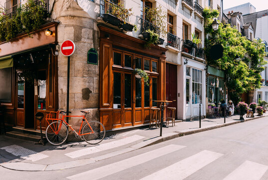 Cozy street with with tables of cafe and old bicycle in Paris, France. Architecture and landmarks of Paris. Postcard of Paris