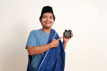 Happy asian muslim boy standing while pointing breaking fasting time. Ramadan concept